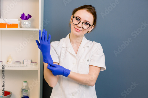 portrait of smiling beautiful woman doctor wearing gloves. medical employee. Cosmetologist before anti ageing procedure for her client. Aesthetic medicine, skin care and cosmetology. photo