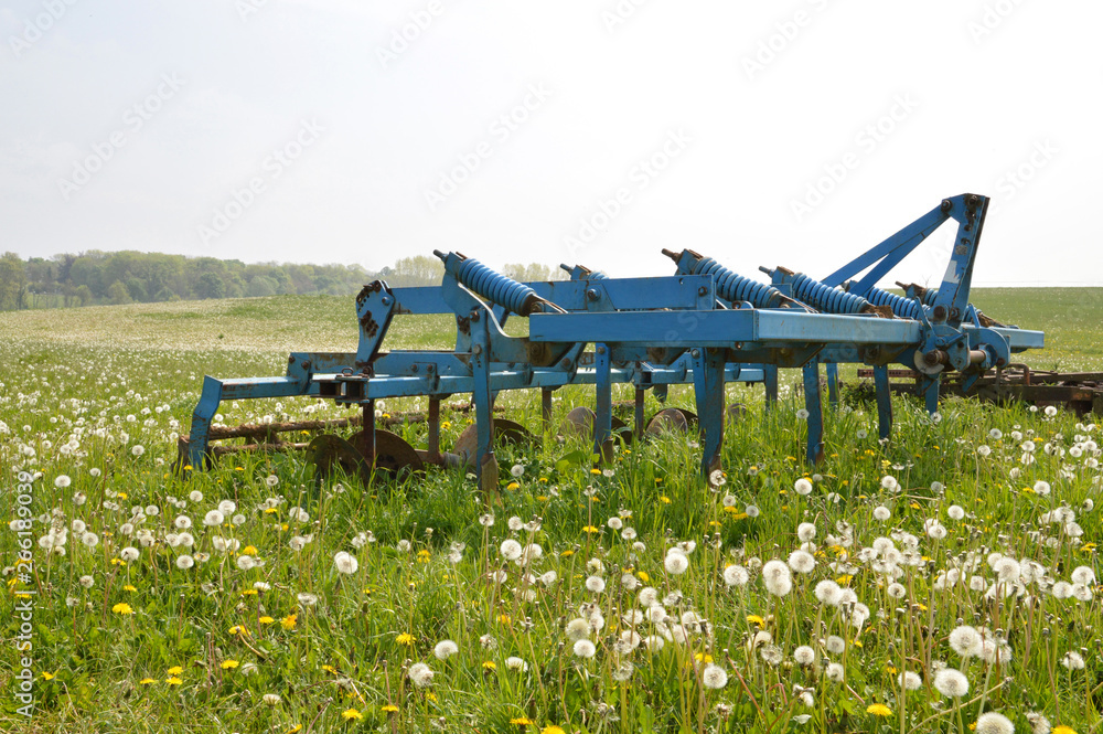Agricultural plow in a green field in the countryside Agricultural plow in a green field in the countryside