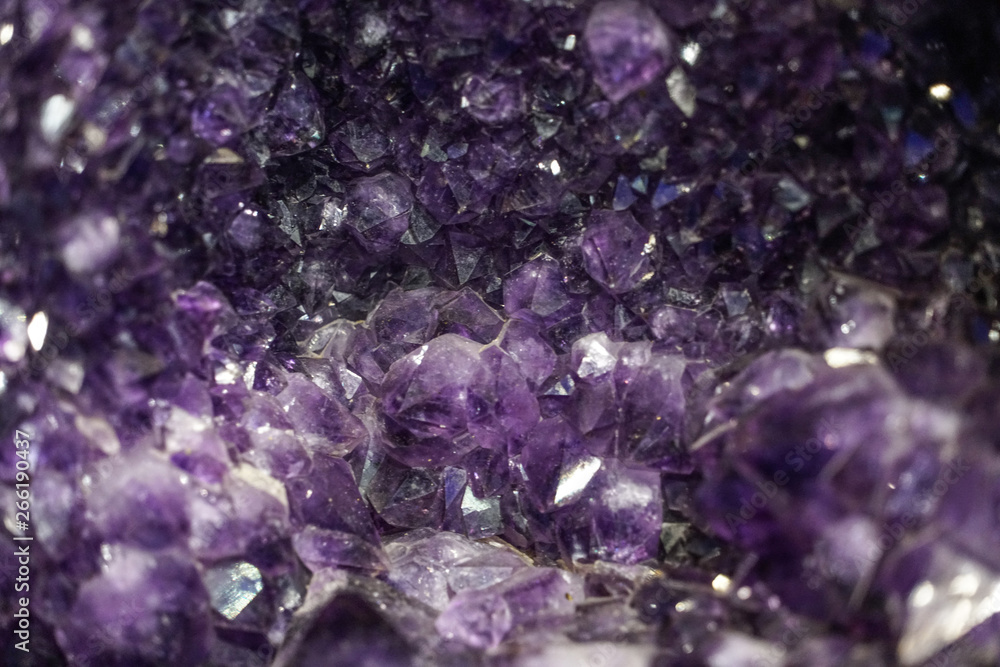 Amethyst cluster rough crystals close up in low light background Amethyst cluster rough crystals close up in low light background