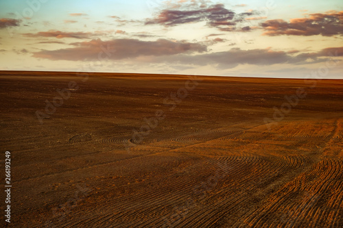 agricultural spring ploughed field before sowing at sunset