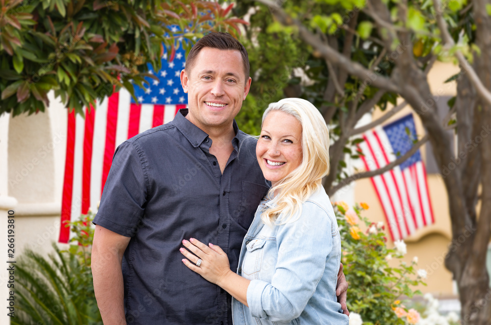 Happy Couple In Front of Houses with American Flags Happy Couple In Front of Houses with American Flags