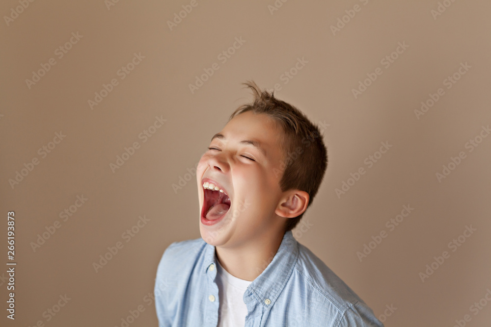 Portrait of an emotional teen boy in casual on beige background Portrait of an emotional teen boy in casual on beige background