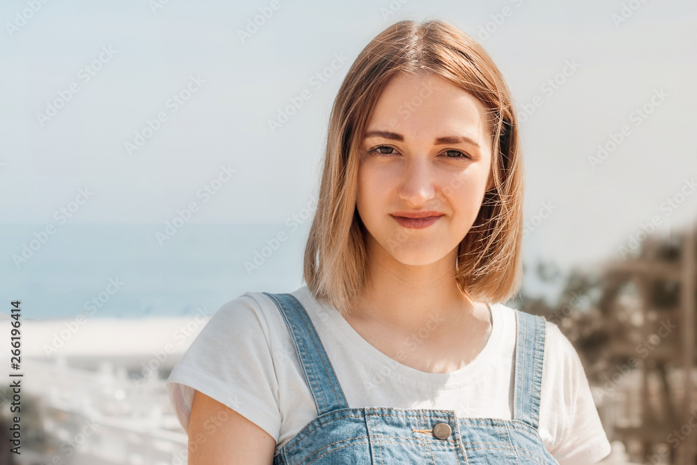 Portrait of a beautiful young girl against the sea on a summer day Portrait of a beautiful young girl against the sea on a summer day