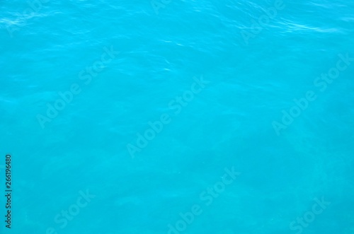 Panoramic background with ripples on water, close up. Sea water surface in sunlight. Beautiful clear blue water background.