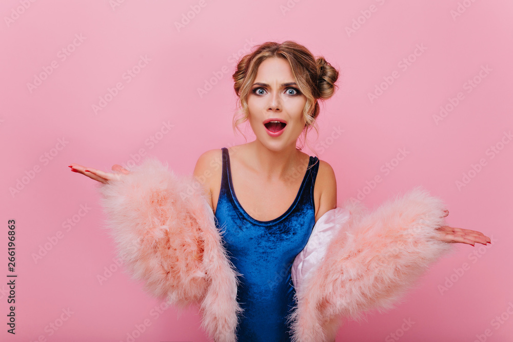 Close-up portrait of disgruntled curly girl in blue bodysuit and fluffy coat, standing on pink background. Indignant young woman with cute hairstyle posing with hands waving and open mouth Close-up portrait of disgruntled curly girl in blue bodysuit and fluffy coat, standing on pink background. Indignant young woman with cute hairstyle posing with hands waving and open mouth