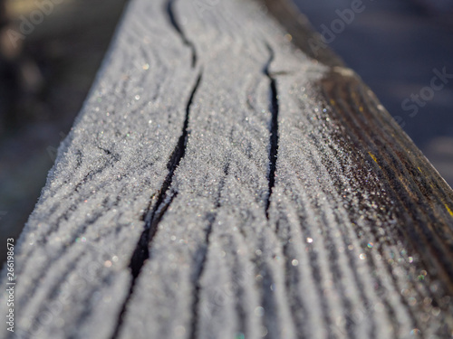 Detalle de hielo sobre un banco de madera en invierno.