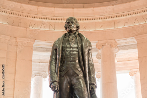 Bronze statue of Thomas Jefferson in Jefferson Memorial in Washington DC as setting sun illuminates interior of the monument photo