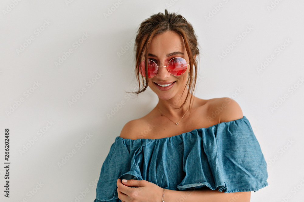 Close up portrait of european pretty lady with dark hair and tanned skin looking at camera with smile over white wall Close up portrait of european pretty lady with dark hair and tanned skin looking at camera with smile over white wall
