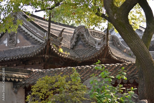 Ancient Chinese house surrounded by tree and greenery. Authentic Asian landscape.