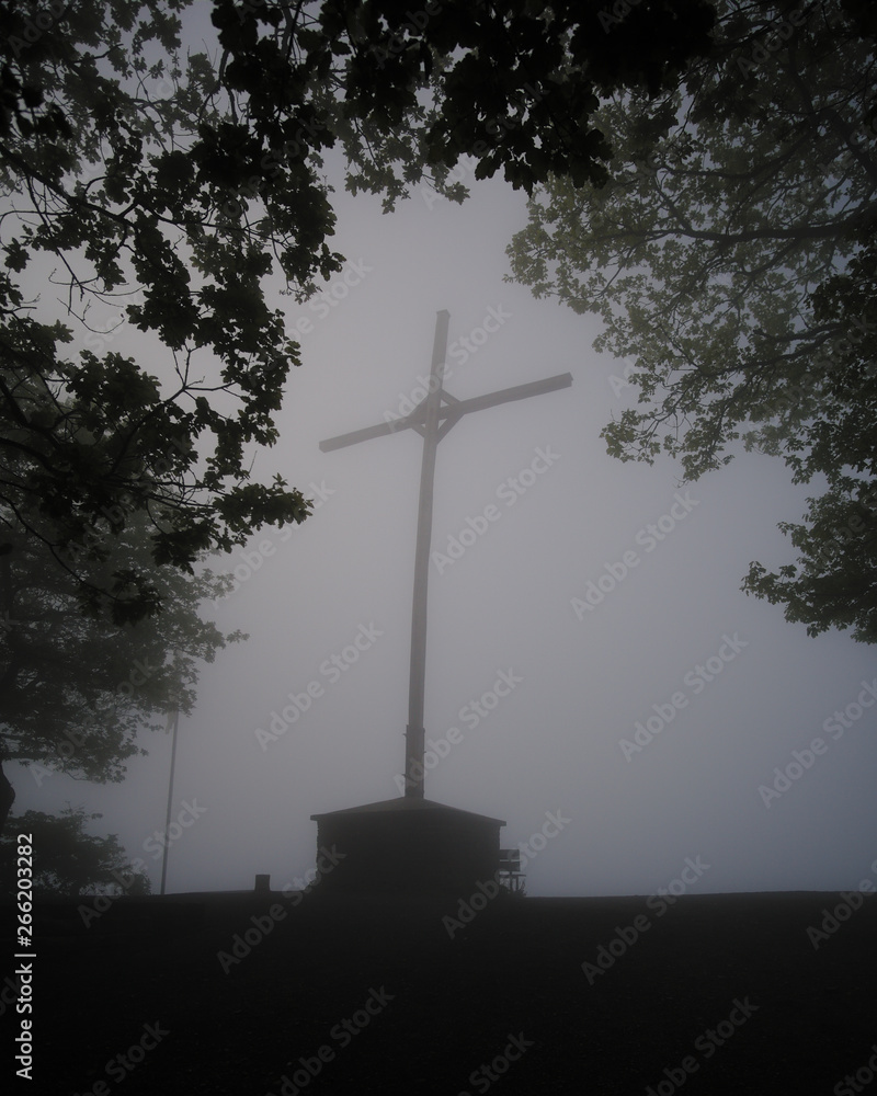 Gipfelkreuz über Bremm in Rheinland-Pfalz, Germany, früh am Morgen in Nebel