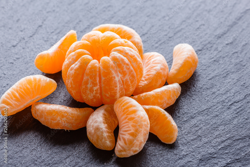 juicy mandarin on a dark stone background juicy mandarin on a dark stone background