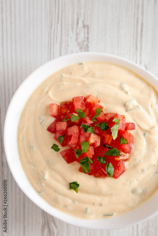 Homemade cheesy dip in a bowl over white wooden background. From above, flat lay, top view. Homemade cheesy dip in a bowl over white wooden background. From above, flat lay, top view.
