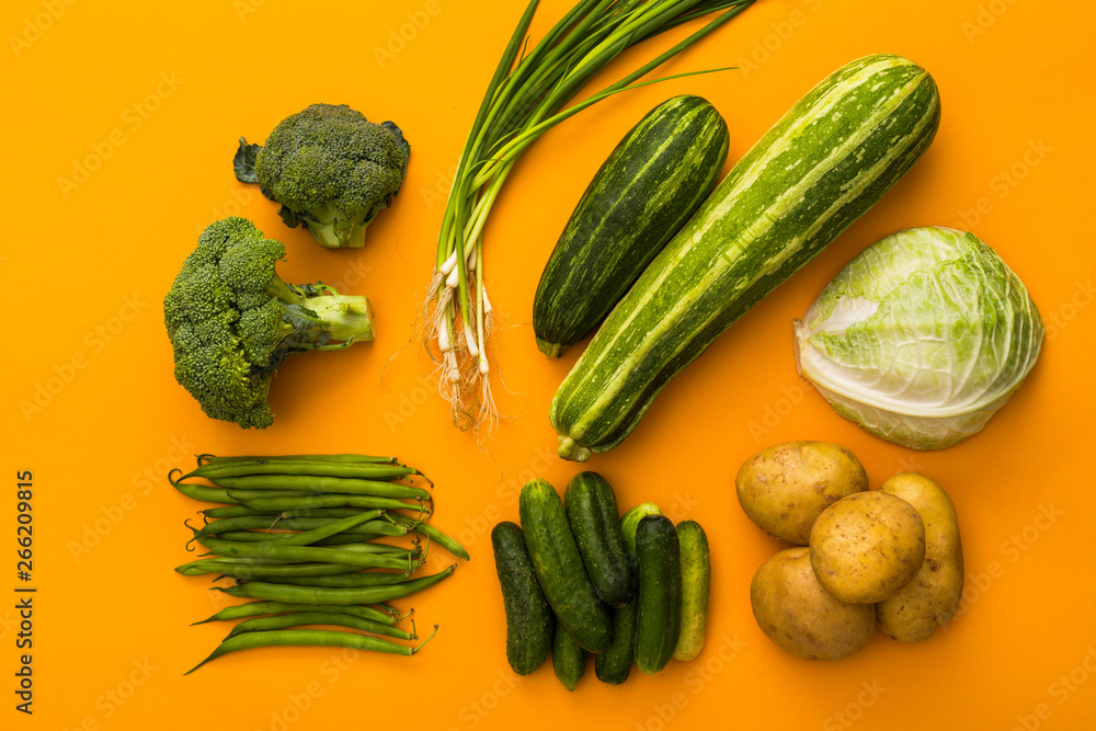 green vegetables on yellow background colorful concept, top view, potatoes, broccoli, cucumber, onion, cabbage, zucchini, beans green vegetables on yellow background colorful concept, top view, potatoes, broccoli, cucumber, onion, cabbage, zucchini, beans