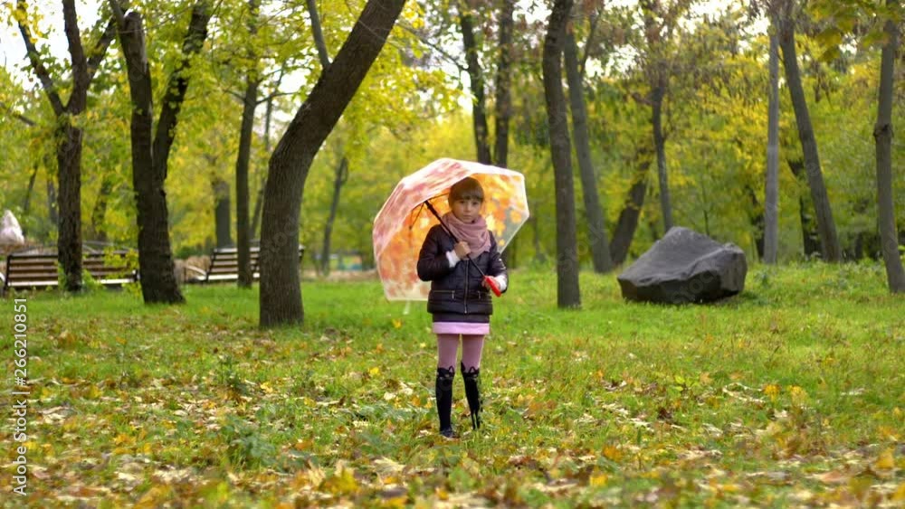 little girl rotates an umbrella in autumn park little girl rotates an umbrella in autumn park