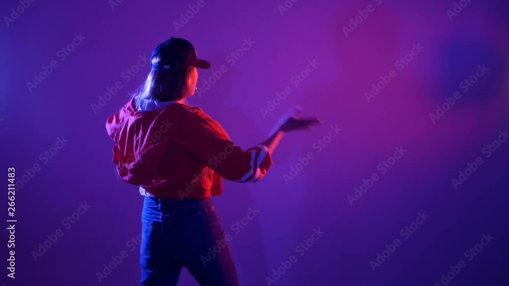 young beautiful girl in a baseball cap dancing hip hop, street dancing in the studio on a purple background, isolated young beautiful girl in a baseball cap dancing hip hop, street dancing in the studio on a purple background, isolated