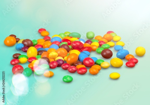 Colorful candies sweets falling out of a glass jar, composition isolated over the white background