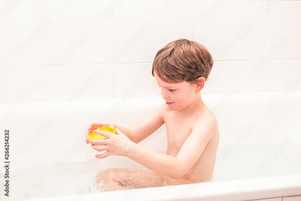 Naklejka premium Happy 5 year old boty playing in a bathtub