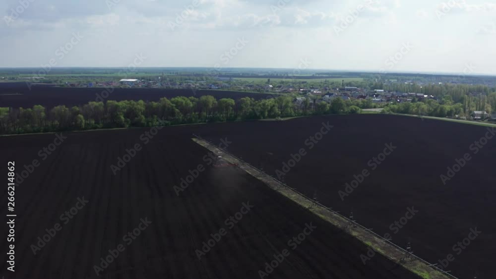 Agricultural industrial tractor plows soil field for sowing , aerial view. Land cultivation, spring farming concept, drone shot Agricultural industrial tractor plows soil field for sowing , aerial view. Land cultivation, spring farming concept, drone shot