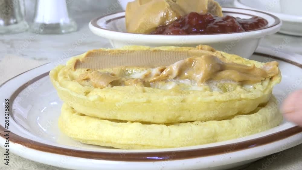 Spreading peanut butter on a hot waffle Spreading peanut butter on a hot waffle