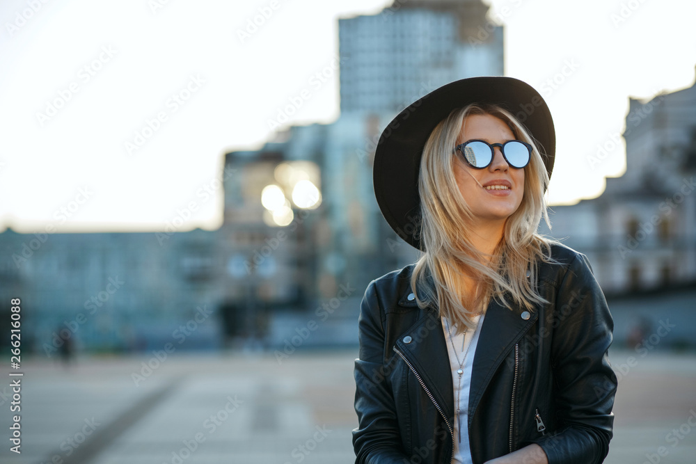 Outdoor fashion portrait of a cheerful blonde woman wearing hat and mirror sunglasses. Space for text Outdoor fashion portrait of a cheerful blonde woman wearing hat and mirror sunglasses. Space for text