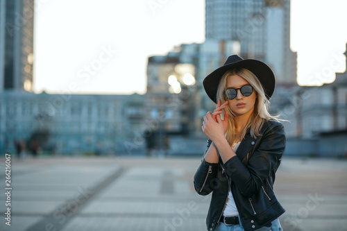 Outdoor fashion portrait of a gorgeous blonde woman wearing hat and mirror glasses. Space for text