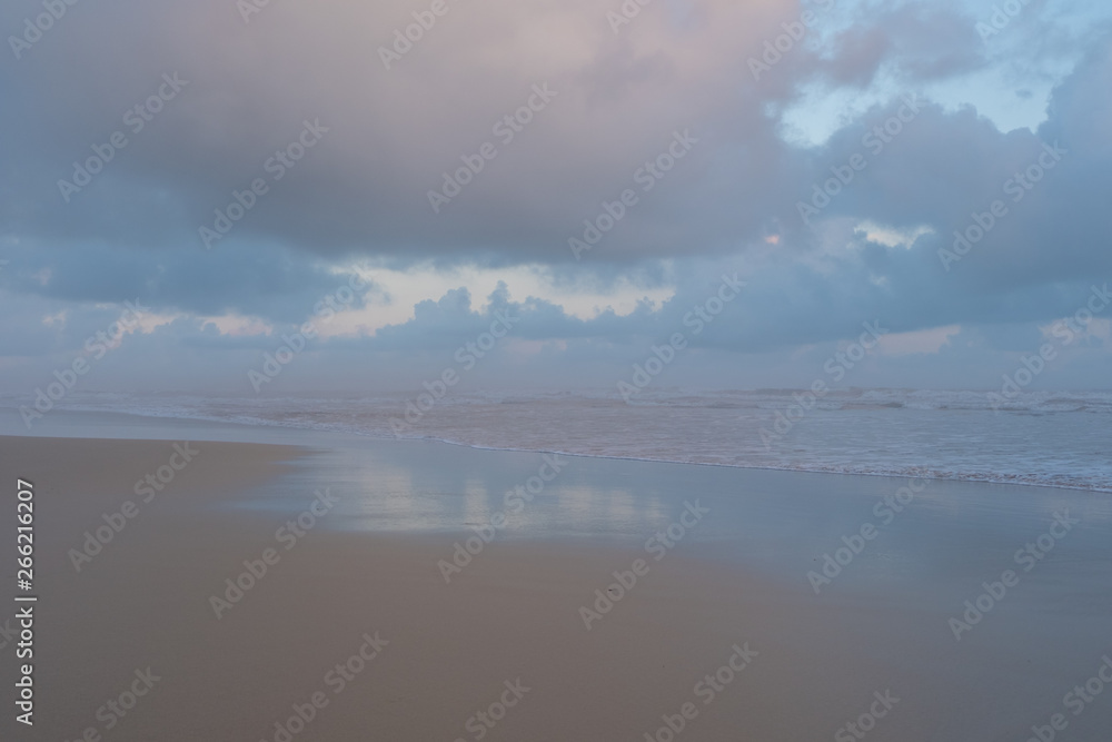 Morgan Bay beach at sunset, on the Wild Coast, Eastern Cape, South Africa. The clouds are reflected in the water on the sand. 
