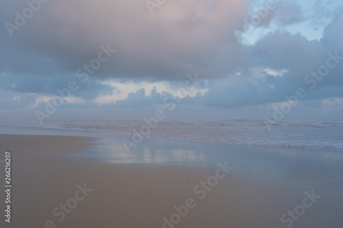 Morgan Bay beach at sunset, on the Wild Coast, Eastern Cape, South Africa. The clouds are reflected in the water on the sand. 