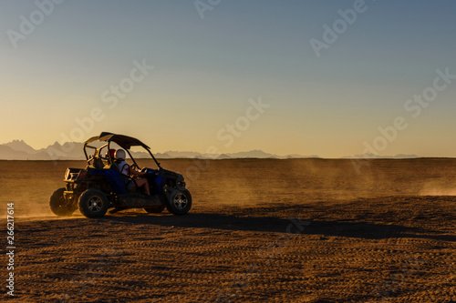 Unrecognizable people driving buggy during safari trip at sunset in Arabian desert not far from the Hurghada city, Egypt photo