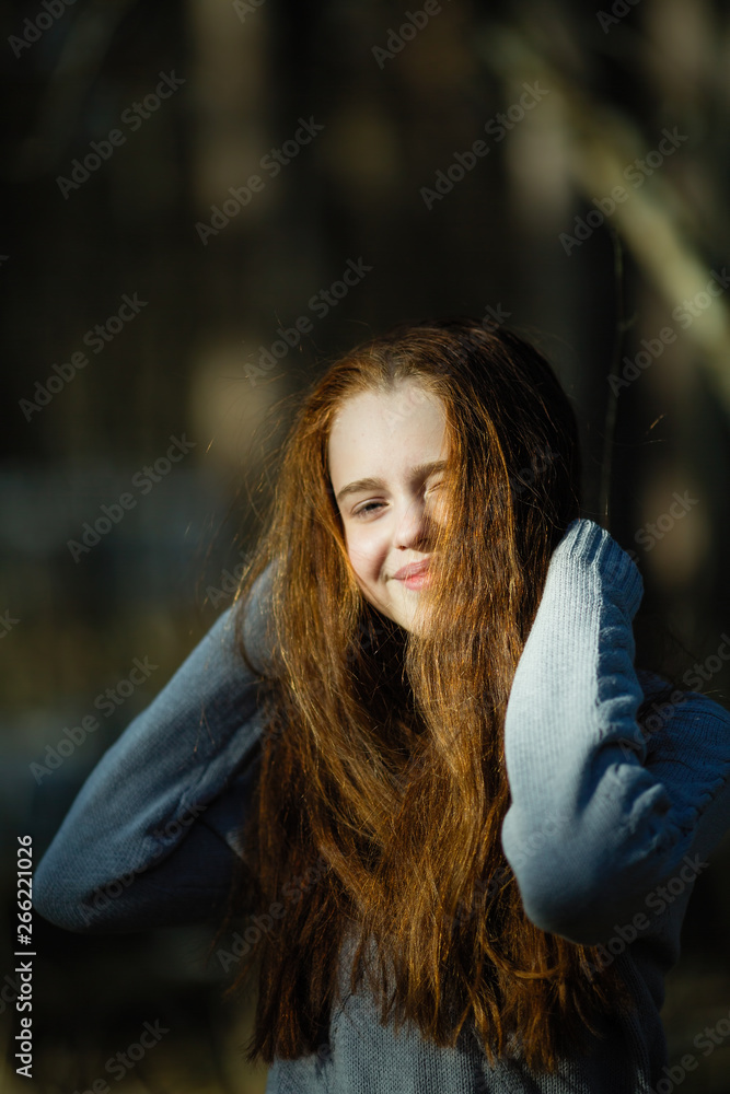 Portrait of cute twelve year old girl with fiery red hair posing in the pine park for a photoshoot. Portrait of cute twelve year old girl with fiery red hair posing in the pine park for a photoshoot.