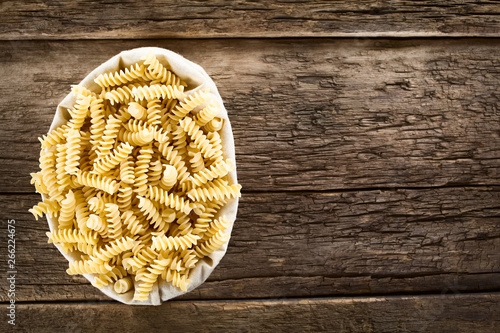 Rohe Spirelli oder Spiralnudeln auf rustikalem Holz (Selektiver Fokus, Fokus auf die obere Pasta) photo