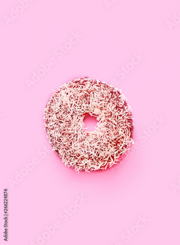 Top view photo of a glazed coco chocolate donut with pink background and copy space