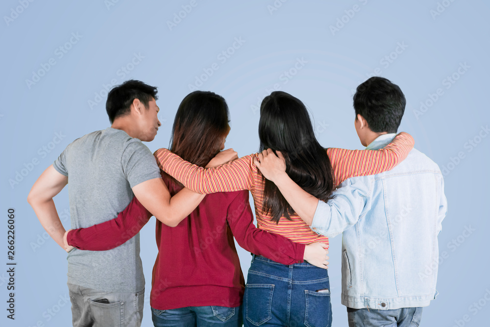 Four best friends embrace each other on studio Four best friends embrace each other on studio