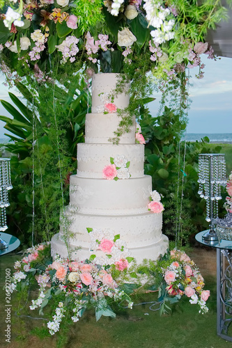 White wedding cake with flowers. Beach wedding