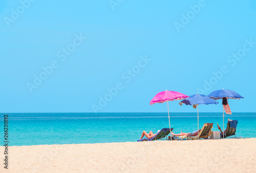 People sunbathing and relaxing on beach chairs. Sea view and blue sky. Summer background - Image