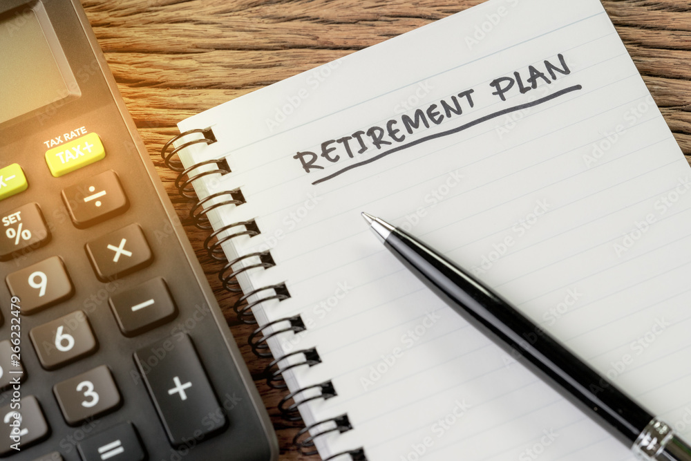 Retirement plan concept, calculator with empty notepad with pen and handwriting headline as Retirement Plan on wood table, plan of saving and investment for expense after retire life Retirement plan concept, calculator with empty notepad with pen and handwriting headline as Retirement Plan on wood table, plan of saving and investment for expense after retire life