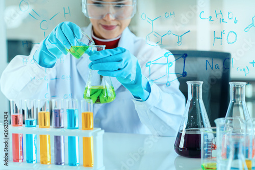 scientist with equipment and science experiments, laboratory glassware containing chemical liquid for research or analyzing a sample into test tube in laboratory