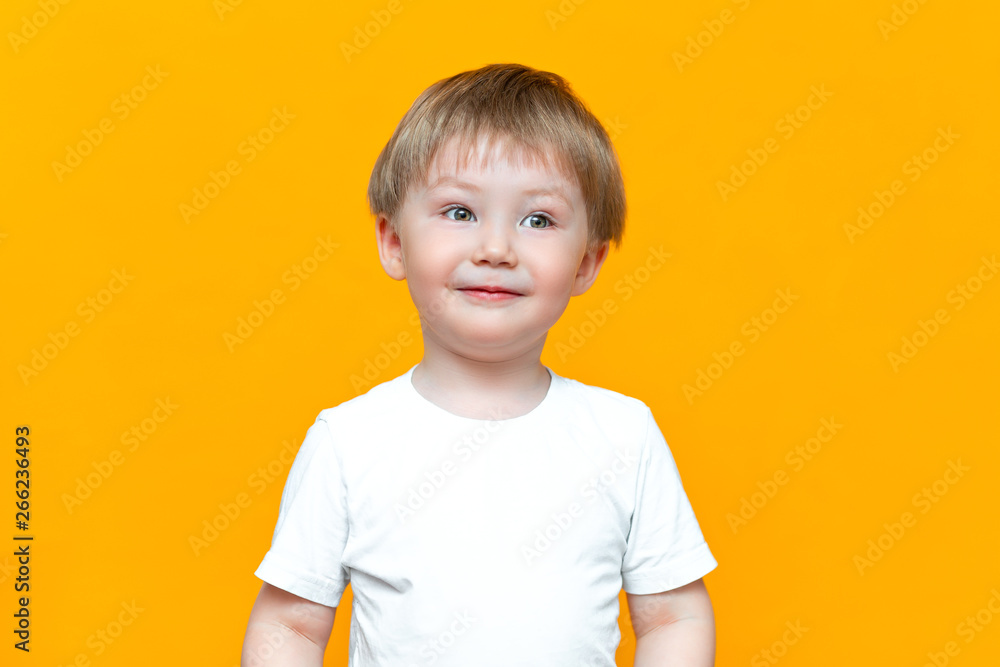 Portrait of smiling happy child 3 years old mixed race half Asian half Caucasian on yellow background with blonde hair and green eyes Portrait of smiling happy child 3 years old mixed race half Asian half Caucasian on yellow background with blonde hair and green eyes