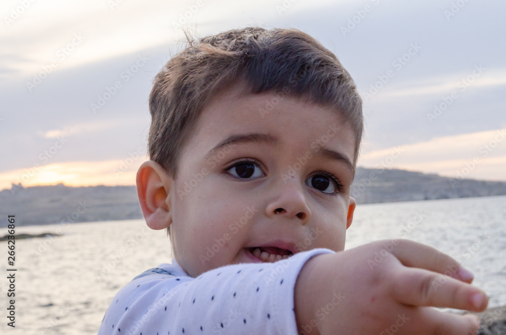 Portrait of cute two years old boy on the beach pointing finger to something close up Portrait of cute two years old boy on the beach pointing finger to something close up