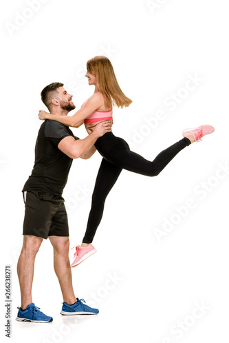 Sporty couple having fun. muscular man carrying fit woman in arms