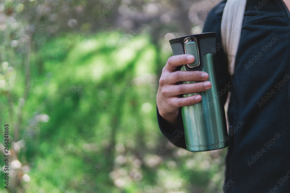 Hand holding a travel coffee mug Hand holding a travel coffee mug