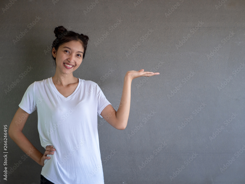 Beauty fashion sexy girl showing empty copy space on the open hand palm for text, gray background. Happy girl presenting point. Proposing product. Advertisement gesture Beauty fashion sexy girl showing empty copy space on the open hand palm for text, gray background. Happy girl presenting point. Proposing product. Advertisement gesture