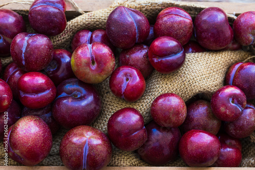 Plums ripe fresh on the wood texture background