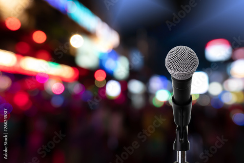 Microphone on stage ..Close up of dynamic microphone setting on stand with colorful night light bokeh background ,celebration event .