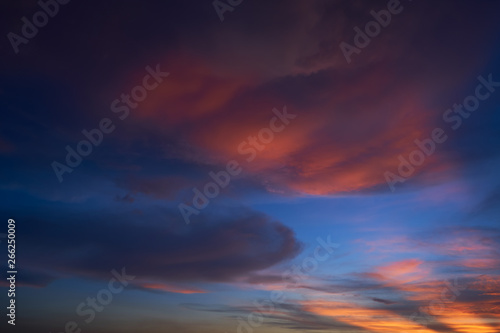 Beautiful vibrant orange cloud and blue sunset sky .