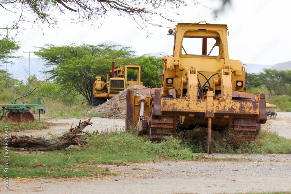 Yellow bulldozer abandoned, damaged and rusted