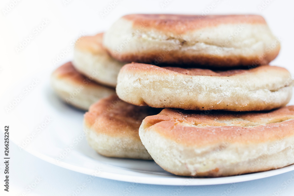 Fried cakes with potato and beans on white table background .