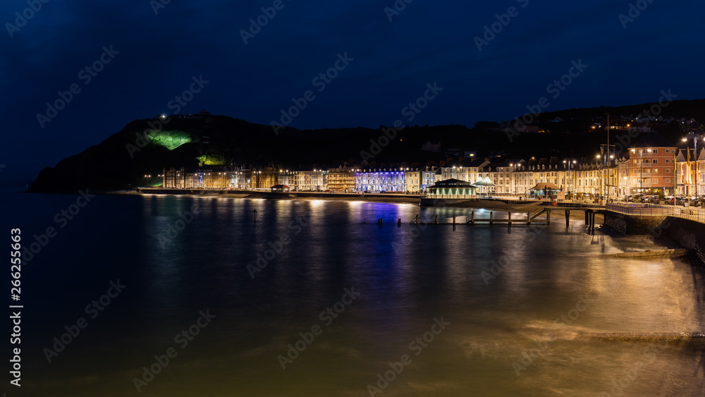 Wonderful view of the night seafront of the illuminated Welsh town of Aberystwyth and the mountain in the background.
