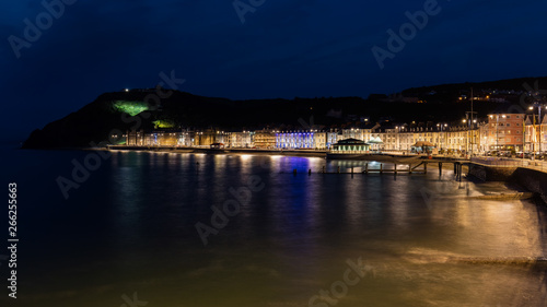 Wonderful view of the night seafront of the illuminated Welsh town of Aberystwyth and the mountain in the background. © wewi-creative