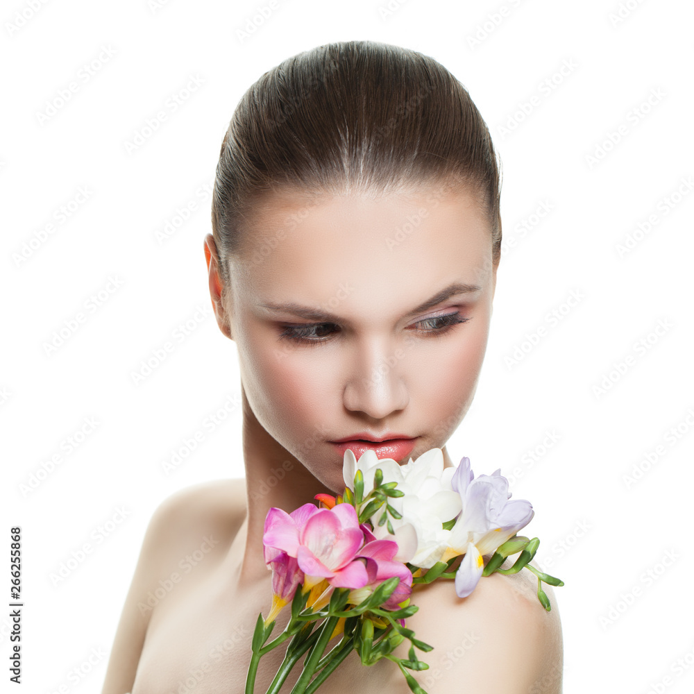 Pretty female face. Beautiful model with clear skin and colorful flowers. Skin care and facial treatment concept
