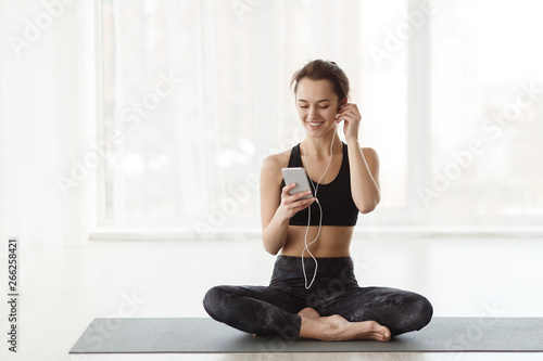 Woman After Practicing Yoga, Relaxing With Smartphone